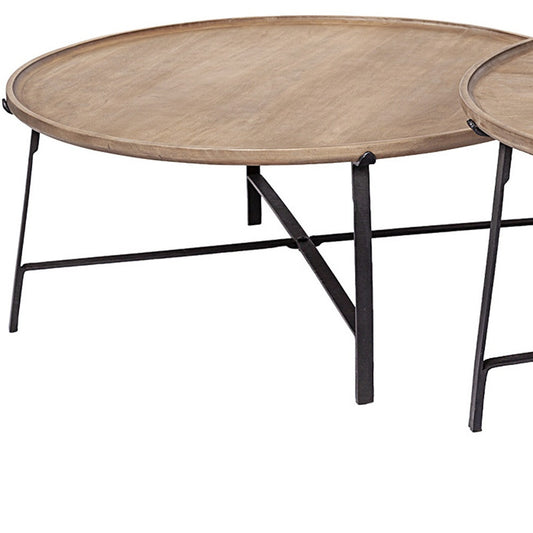 Round wooden coffee table with black metal legs on a white background