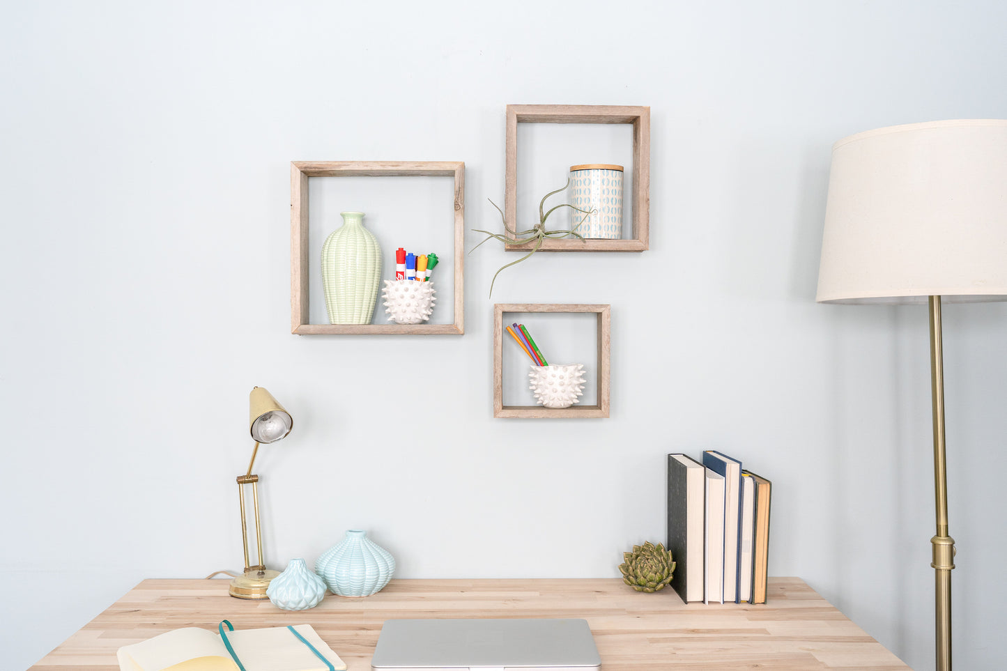 Home office with wooden desk, decorative items, and wall shelves.