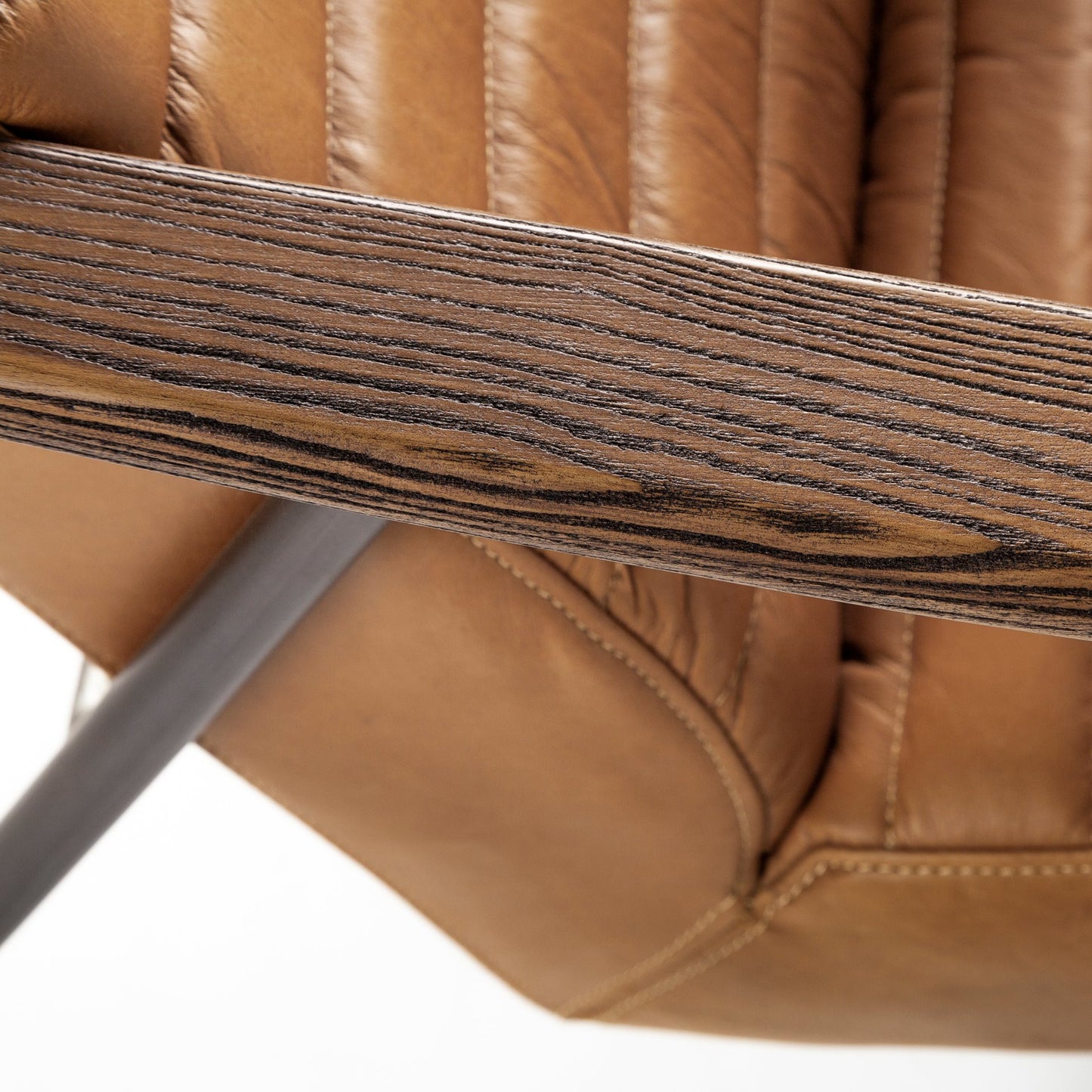 Close-up of a brown leather chair with wooden armrest.