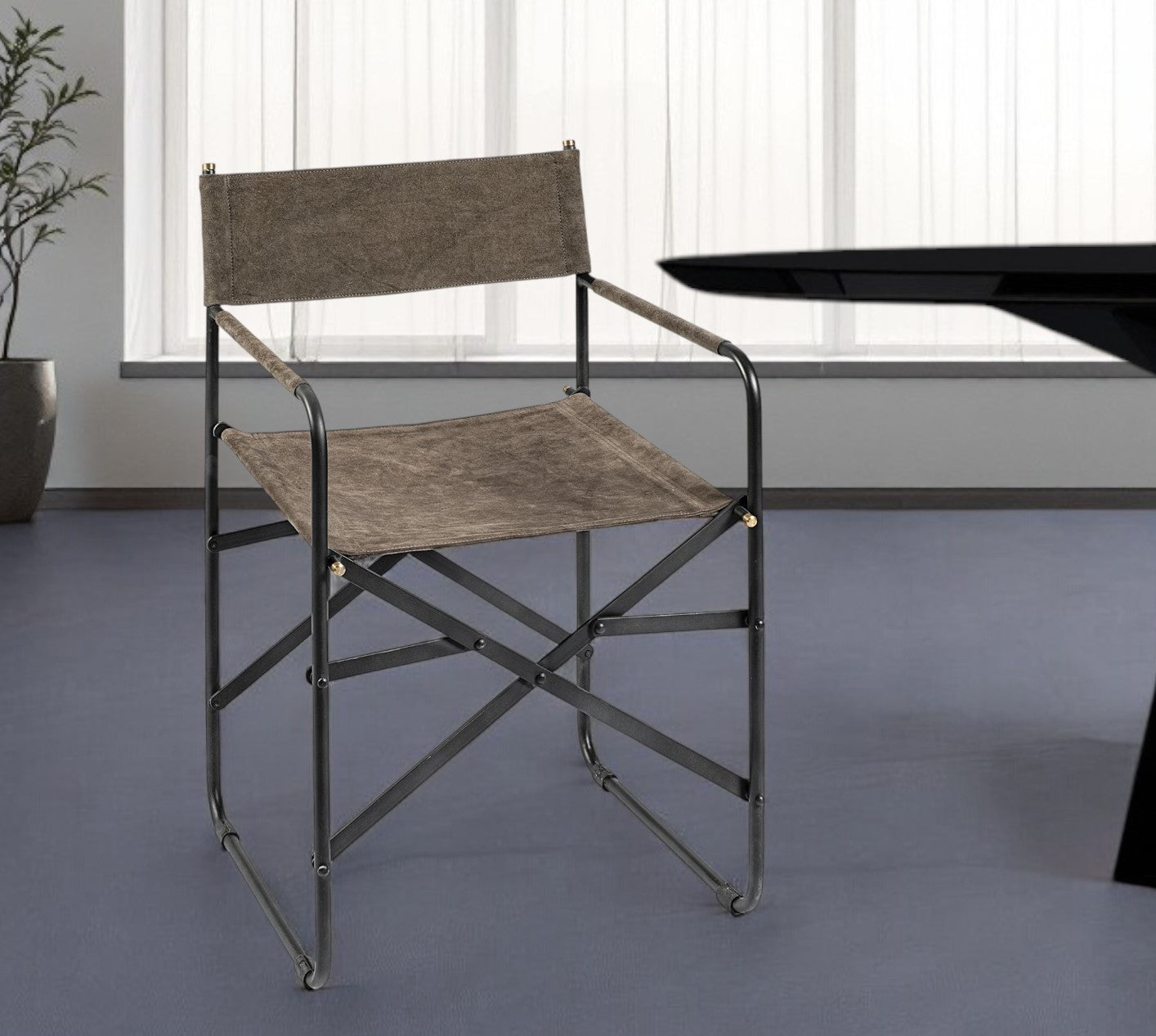 Director's chair with brown seat and backrest in a room with a window and table.