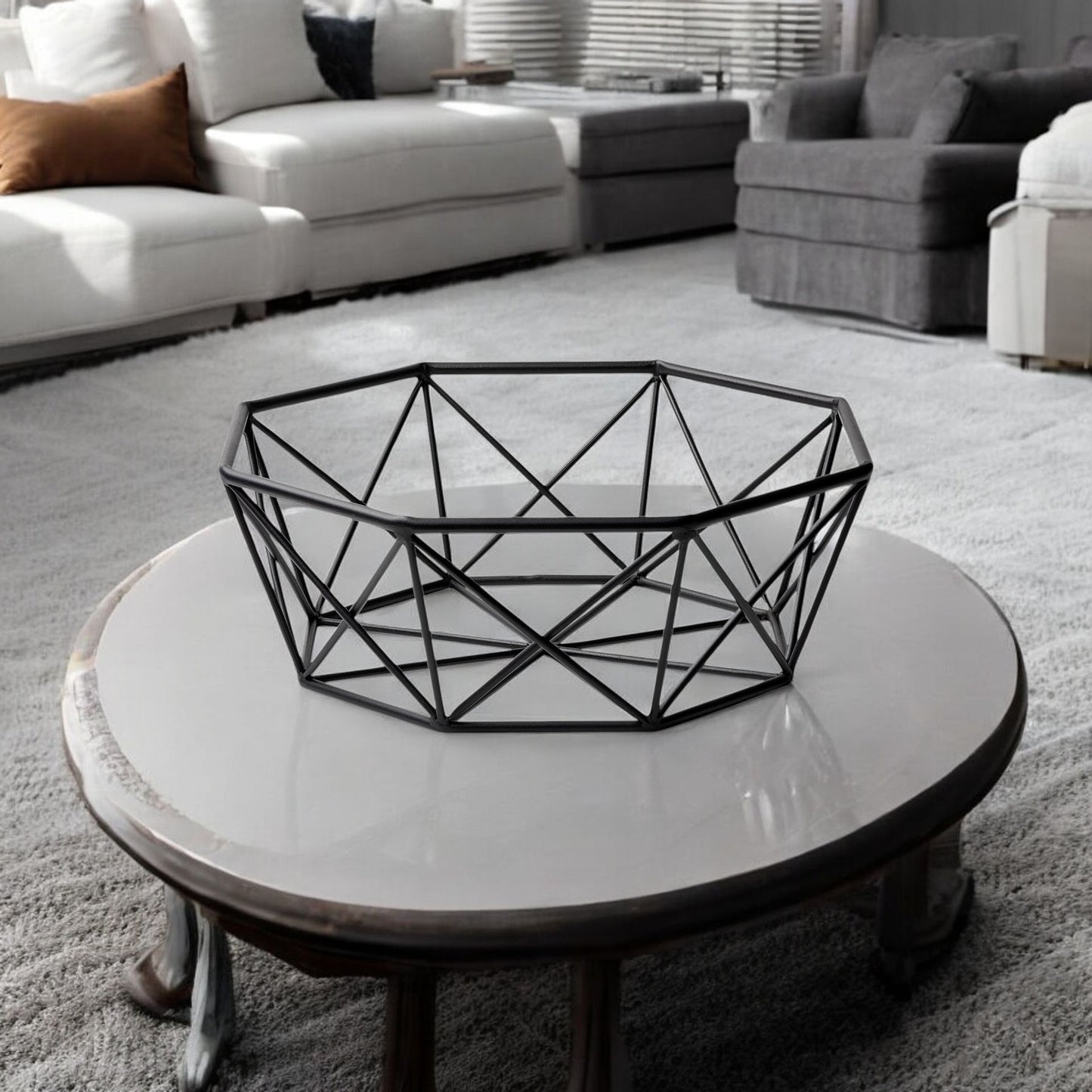 Geometric black wire basket on a round white coffee table in a living room setting.