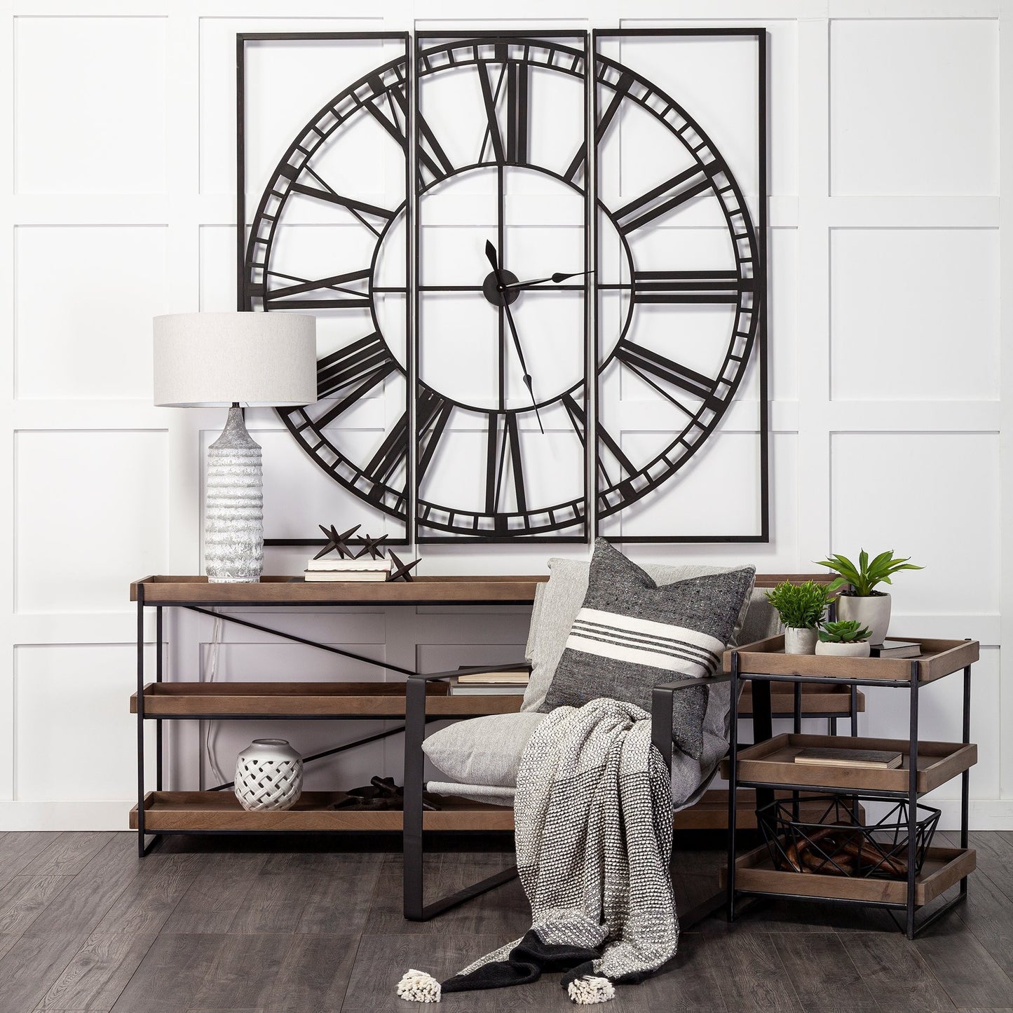 Decorative wall clock above a living room setup with a chair, table, and plants.