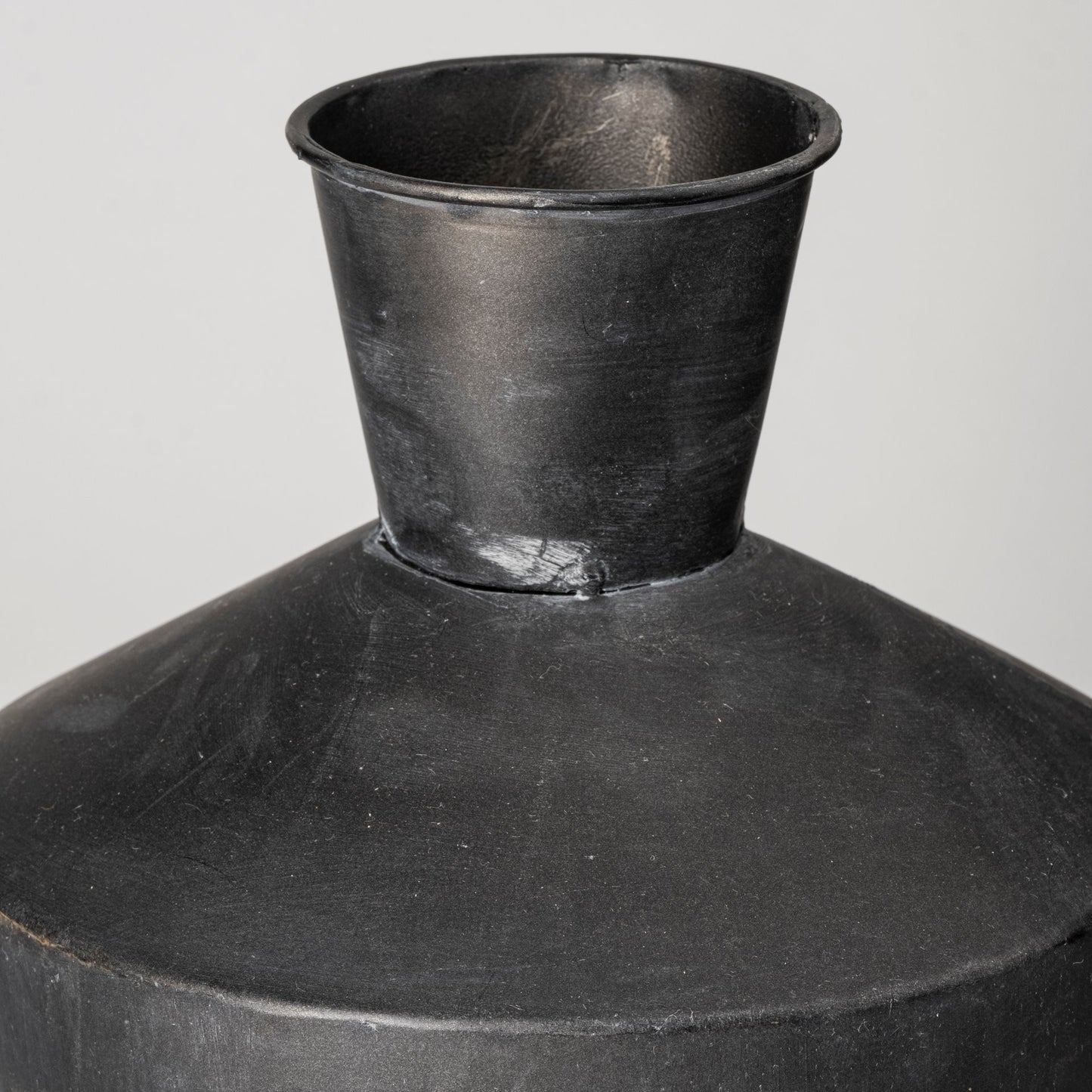 Black ceramic jar with a wide mouth on a white background