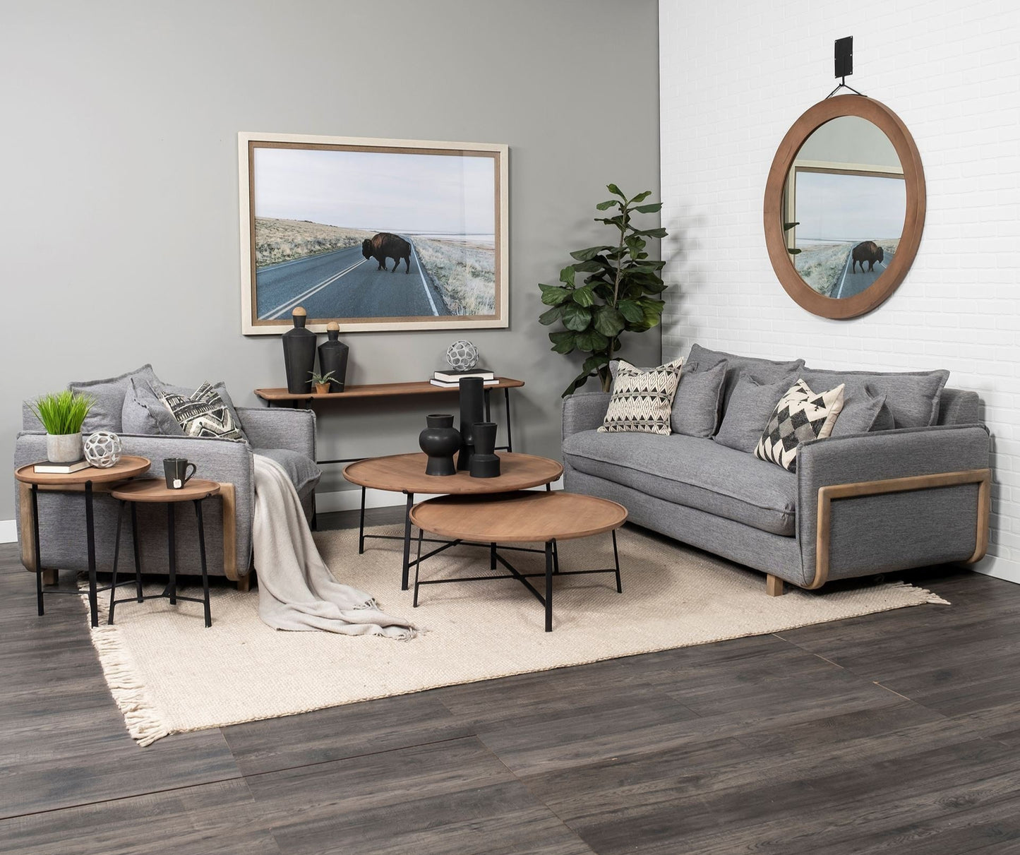 Modern living room with gray sectional sofa, wooden coffee tables, and decorative items.