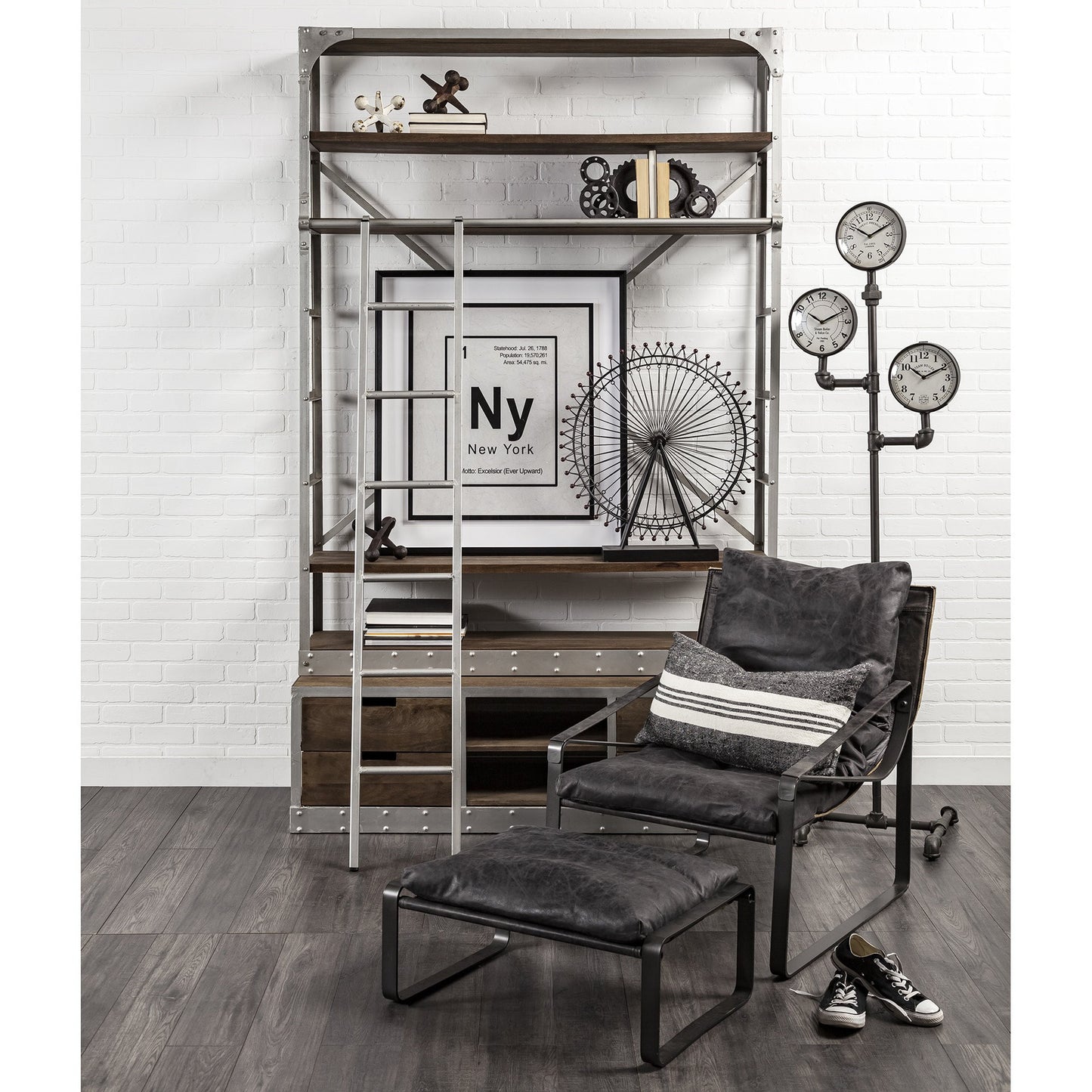 Modern interior with a dark gray armchair, ottoman, and decorative items on a white brick wall.