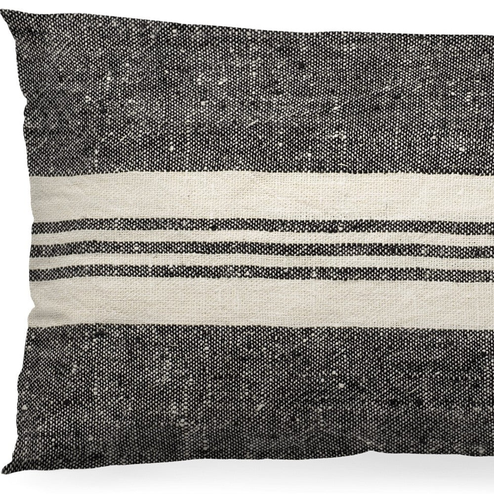 Textured black and white pillow with horizontal stripes on a white background