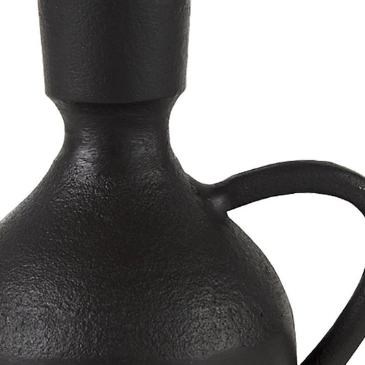 Close-up of a black ceramic vase with a handle on a white background