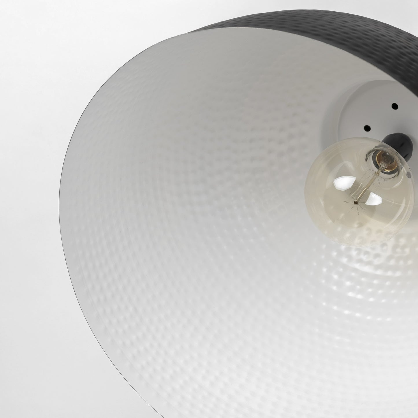 Close-up of a ceiling light fixture with a textured white shade and visible bulb.