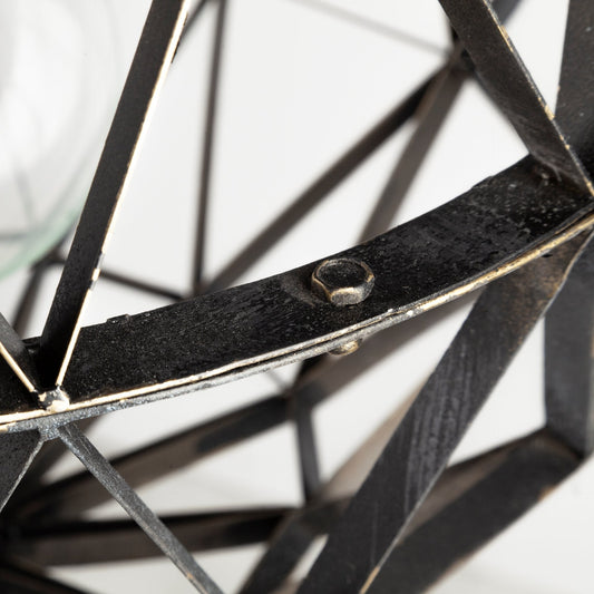 Close-up of a black metal geometric sculpture on a white background