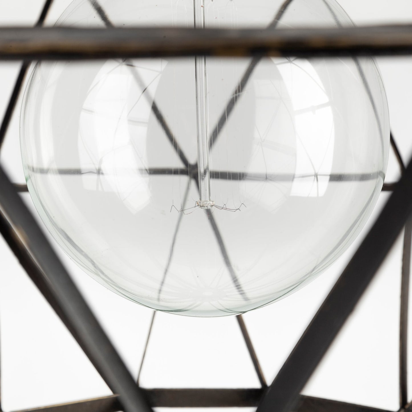 Close-up of a clear glass sphere with metal frame on a white background