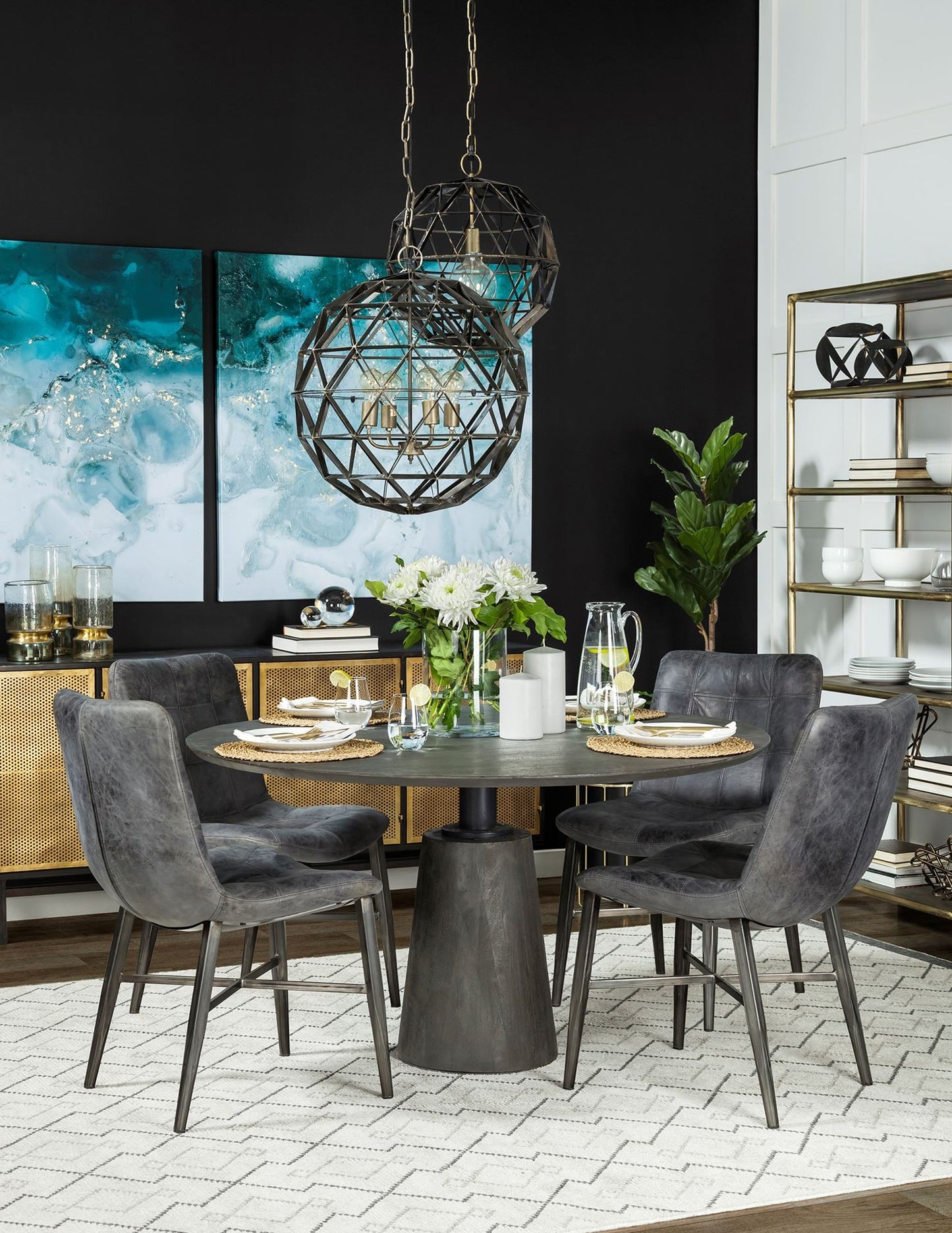 Dining room with a round table and gray chairs, featuring a modern chandelier and decorative elements.
