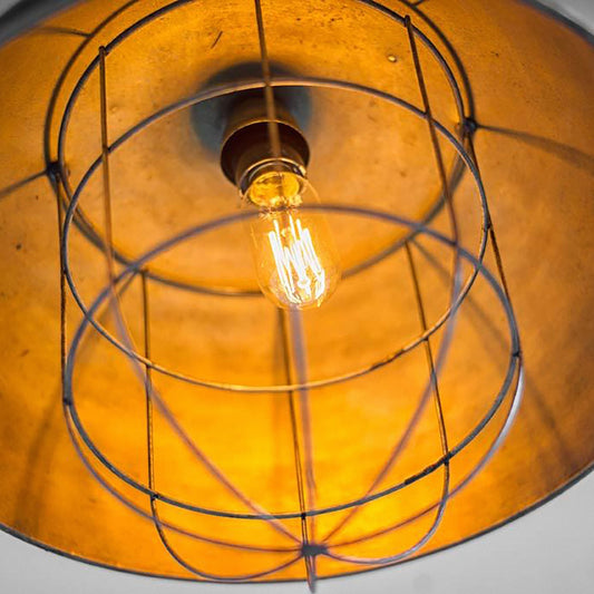 Vintage-style light bulb in a cage with a warm glow