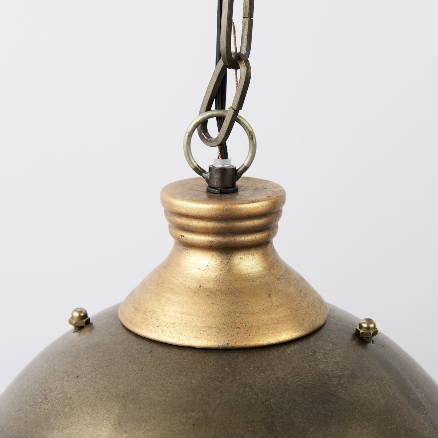 Close-up of a brass pendant light with a white background