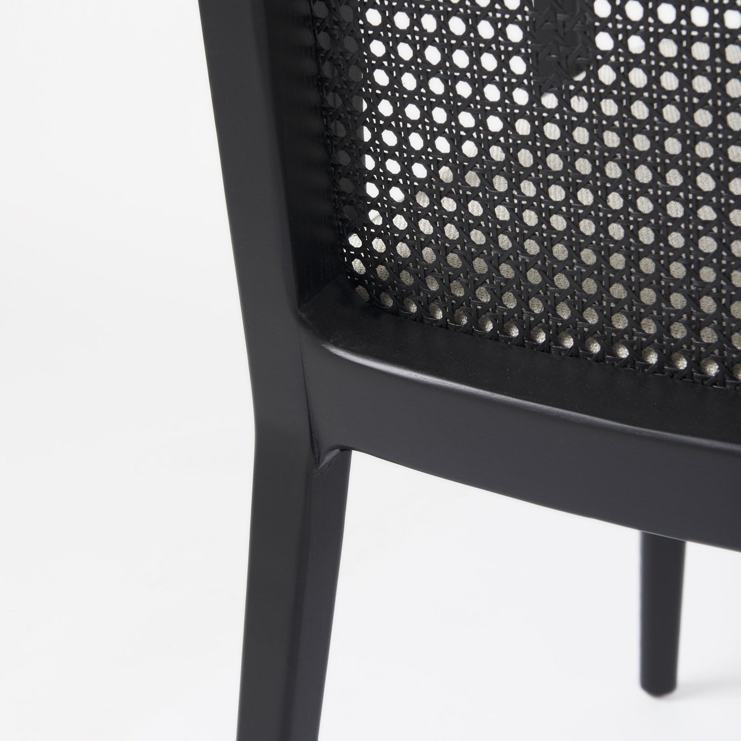 Close-up of a black chair with woven backrest on a white background