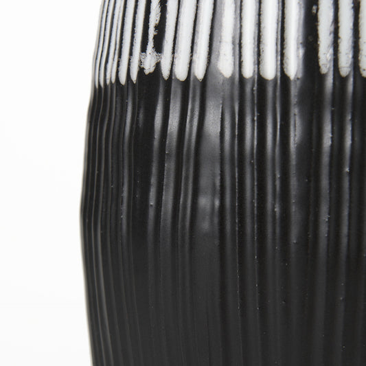 Close-up of a black and white striped vase on a white background