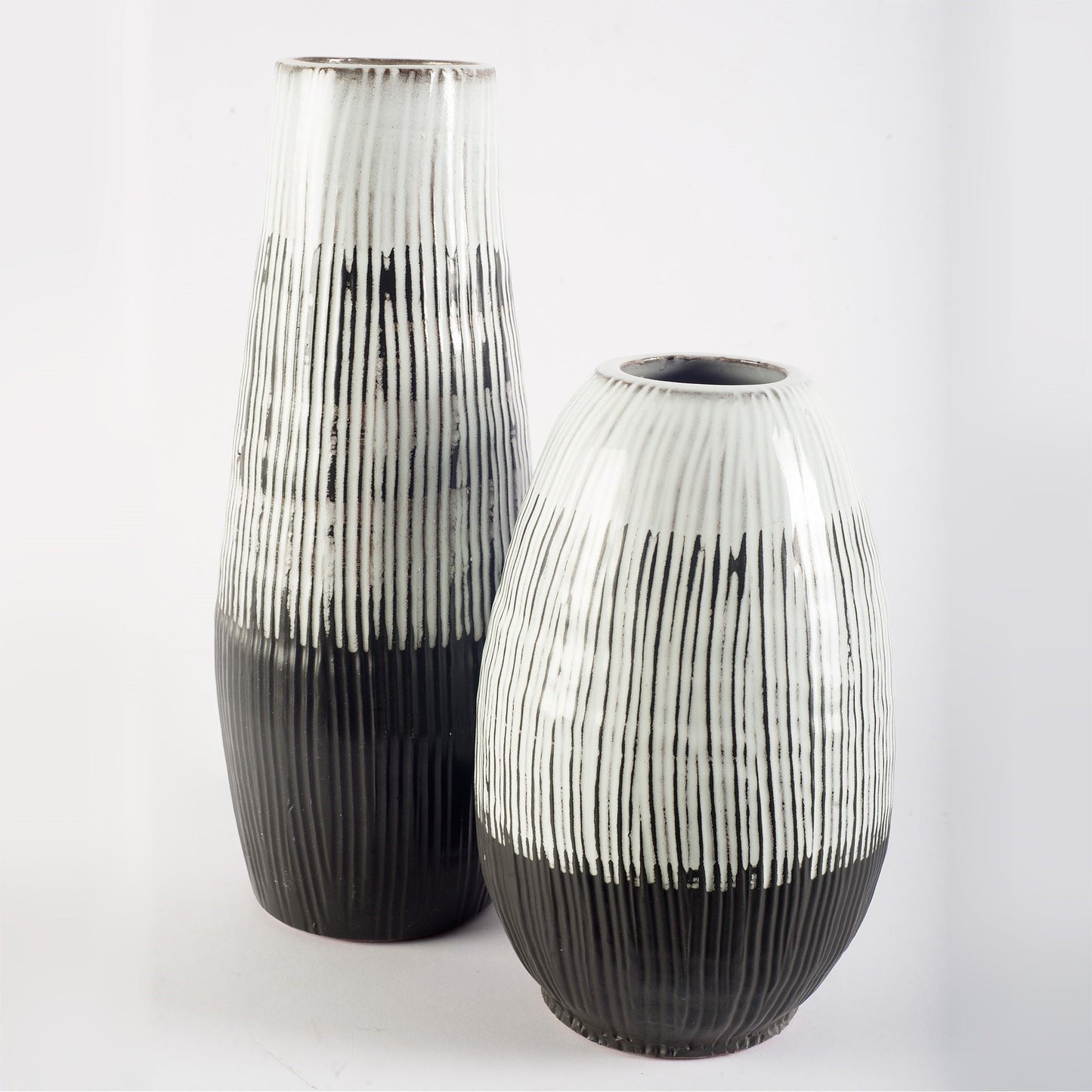 Two black and white striped vases on a light gray background