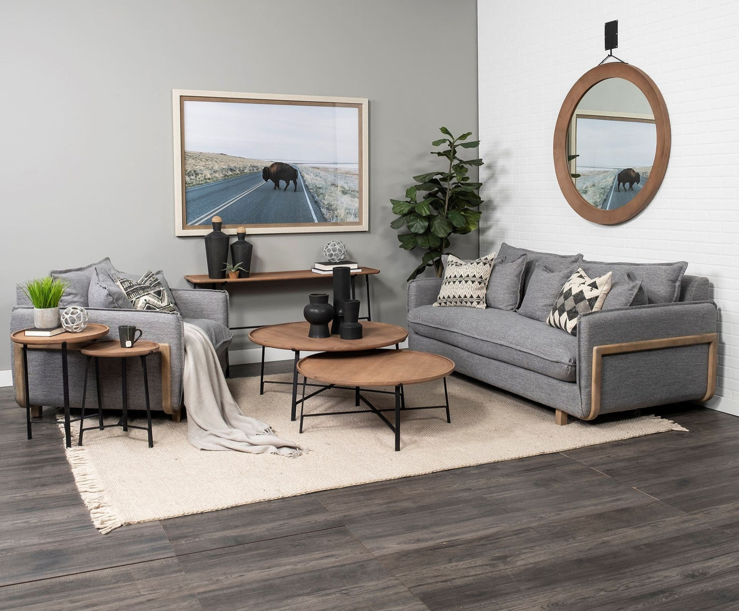 Modern living room with gray sectional sofa, wooden coffee tables, and decorative items.