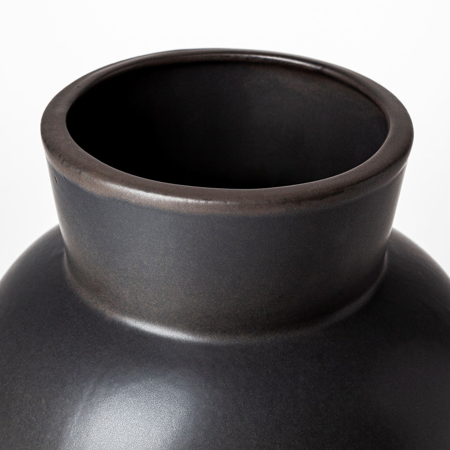 Close-up of a black ceramic vase on a white background