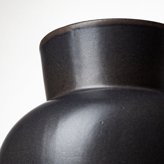 Close-up of a dark ceramic vase on a white background