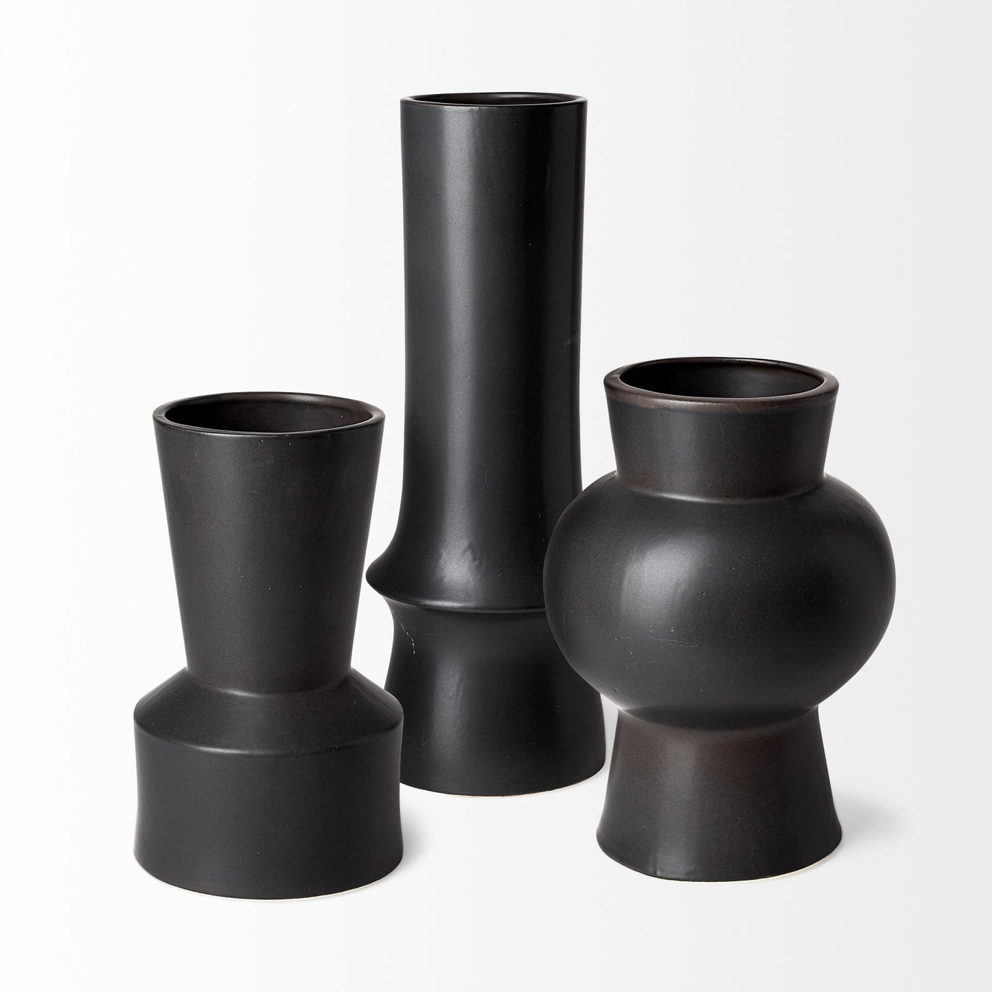 Three black vases of different shapes on a white background