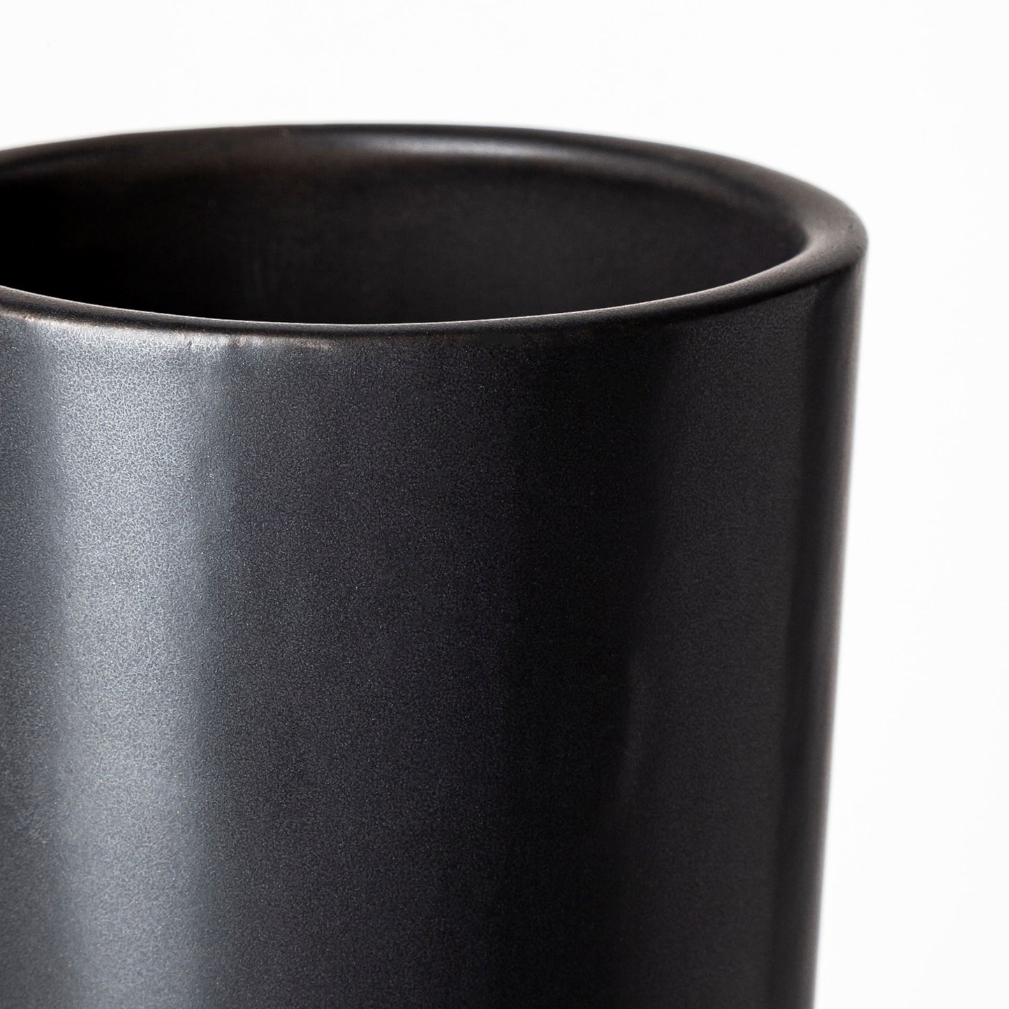 Close-up of a black ceramic vase on a white background