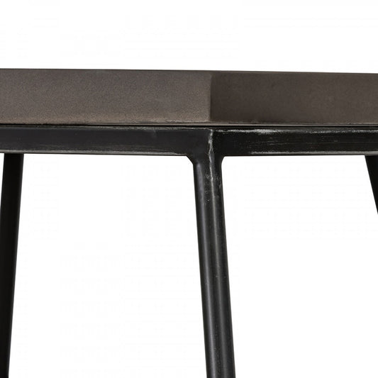 Close-up of a black metal table with a white background