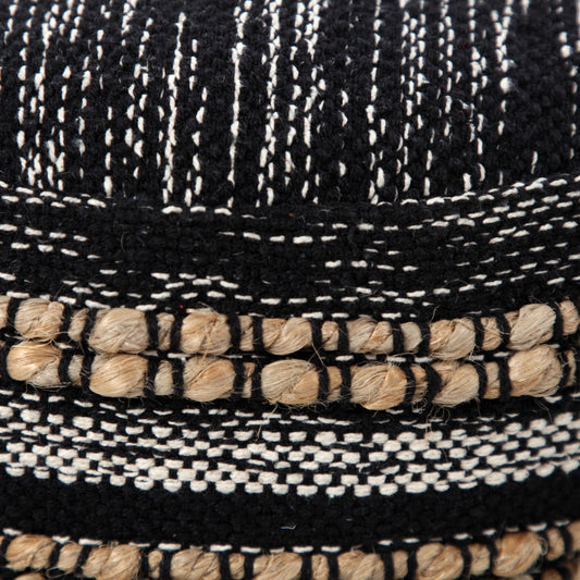 Close-up of a woven black and white hat with natural fiber trim.