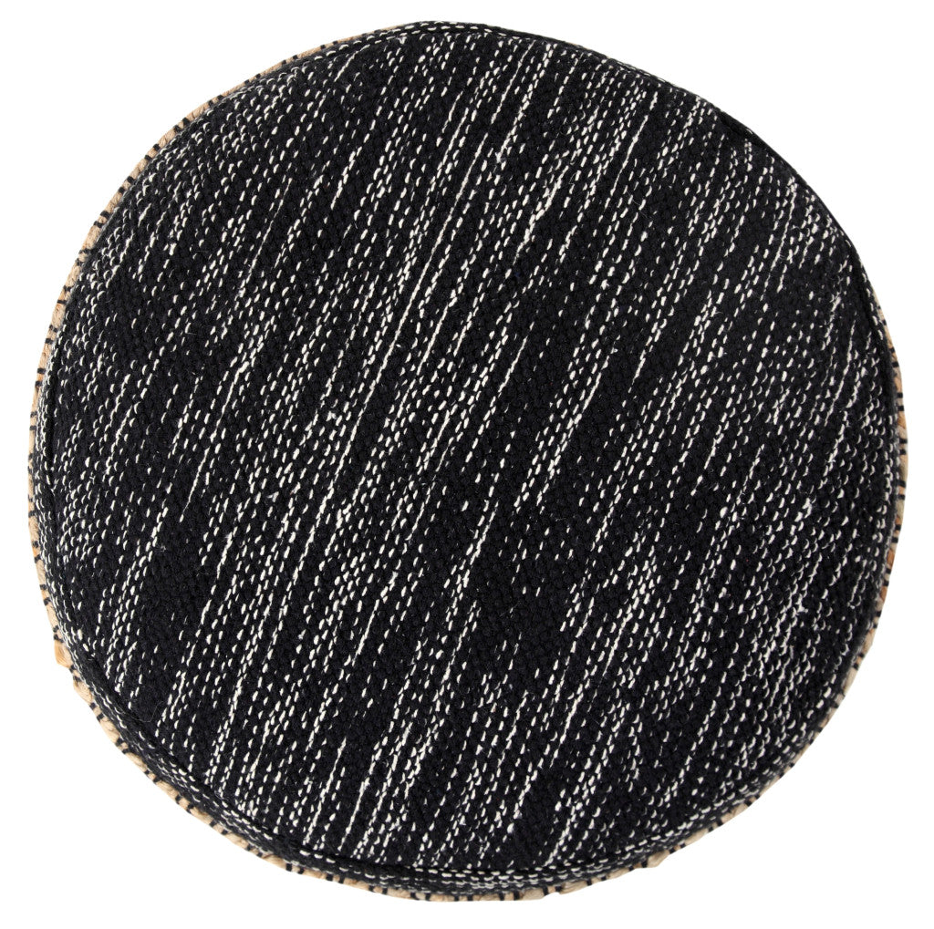 Round black rug with white speckles on a white background