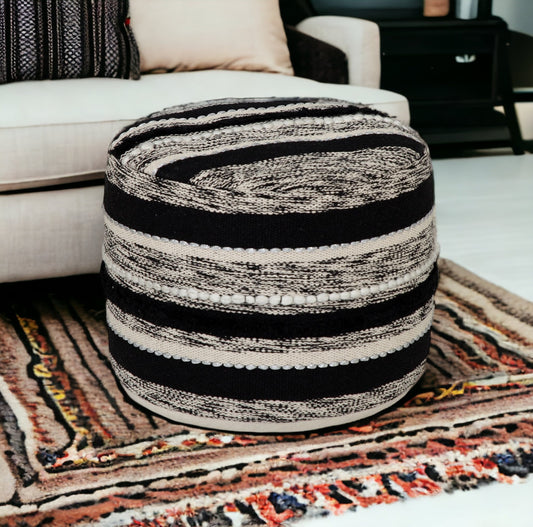 Textured ottoman with black and beige stripes on a patterned rug