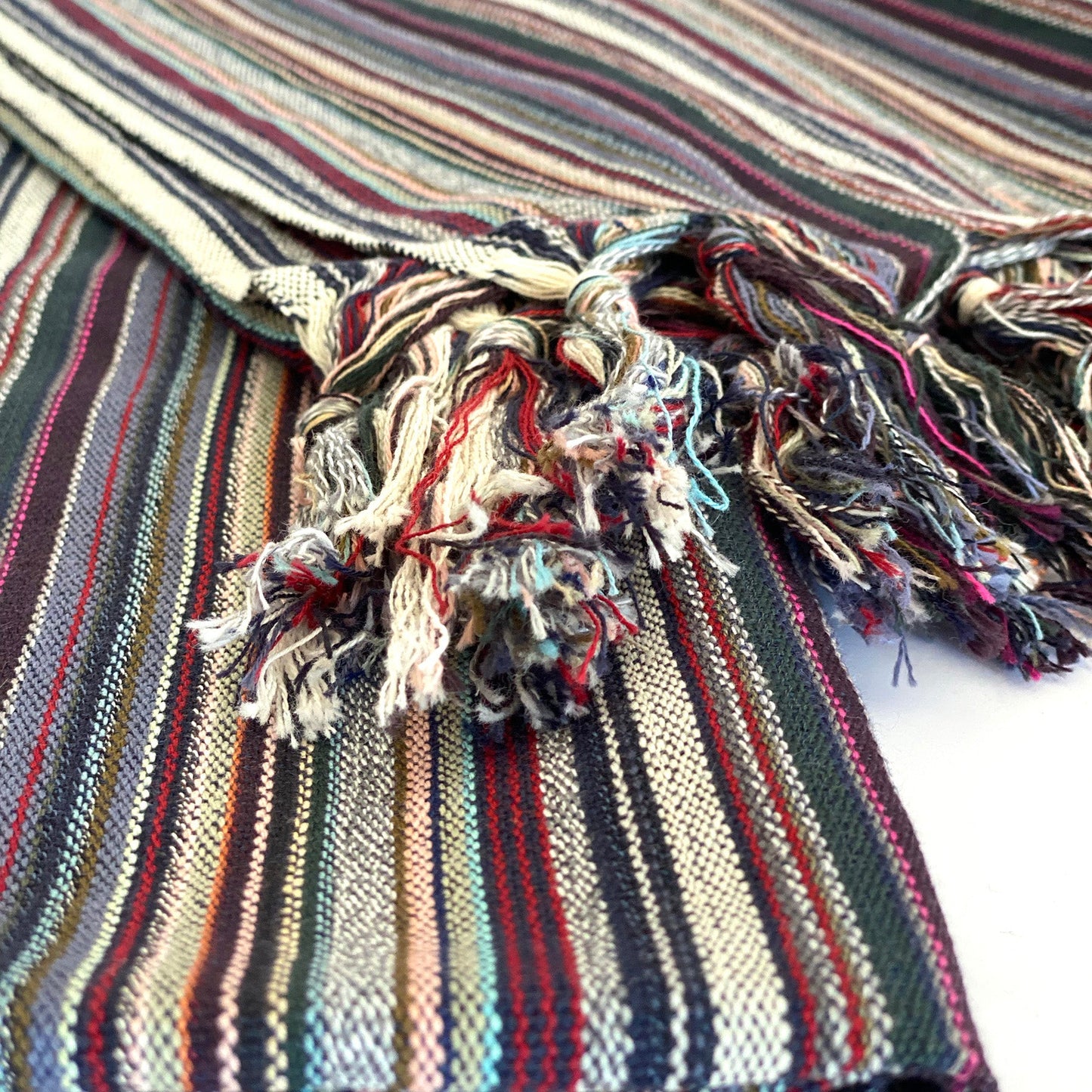 Close-up of a striped fabric with tassels on a white background