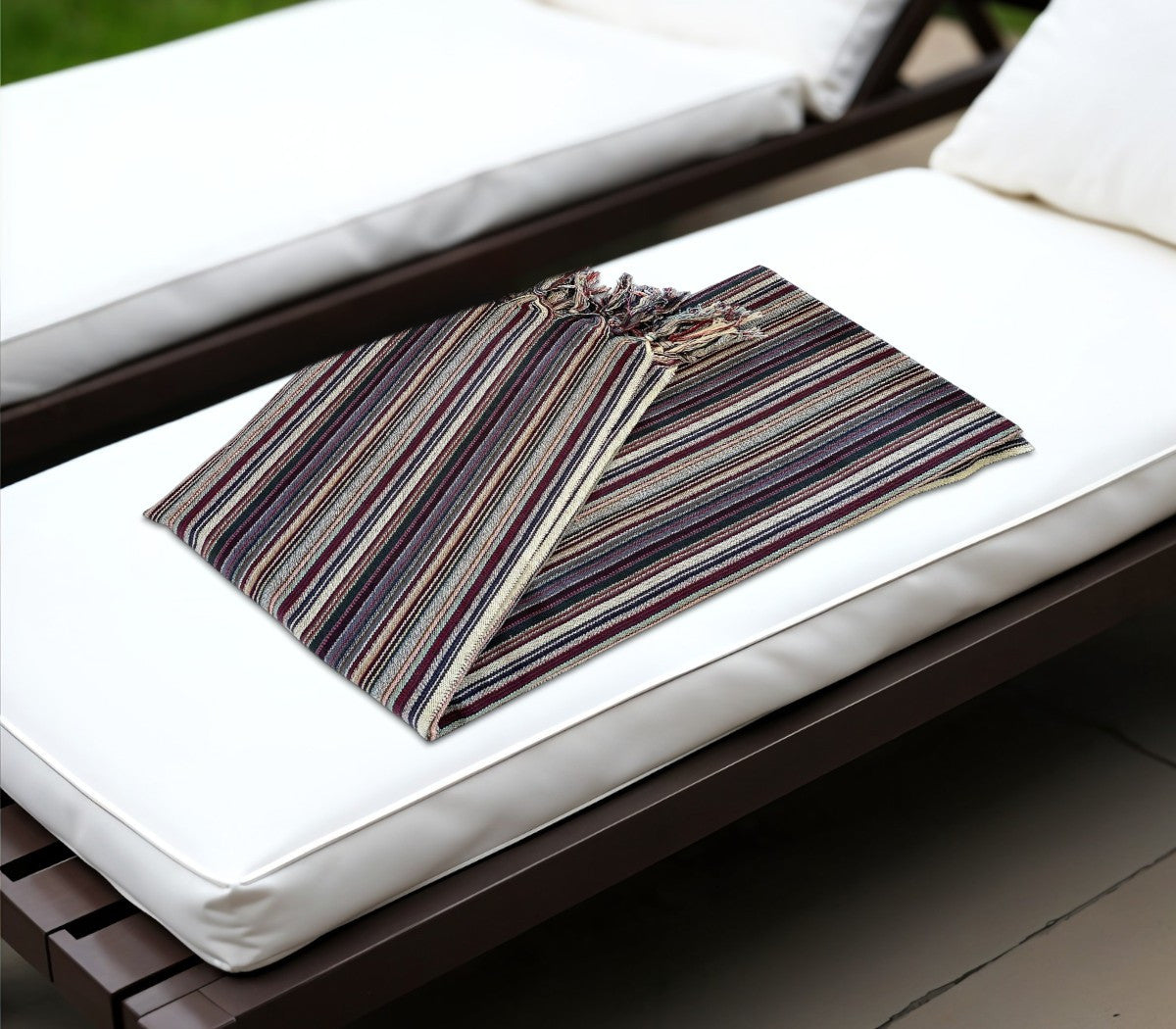 Striped pouch on a white cushioned chair outdoors