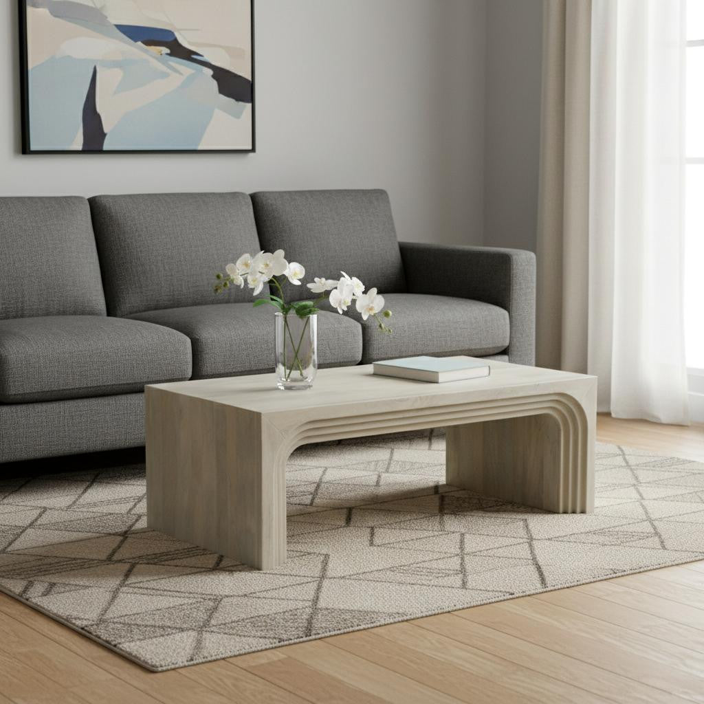 Modern living room with a gray sofa, wooden coffee table, and abstract art on the wall.