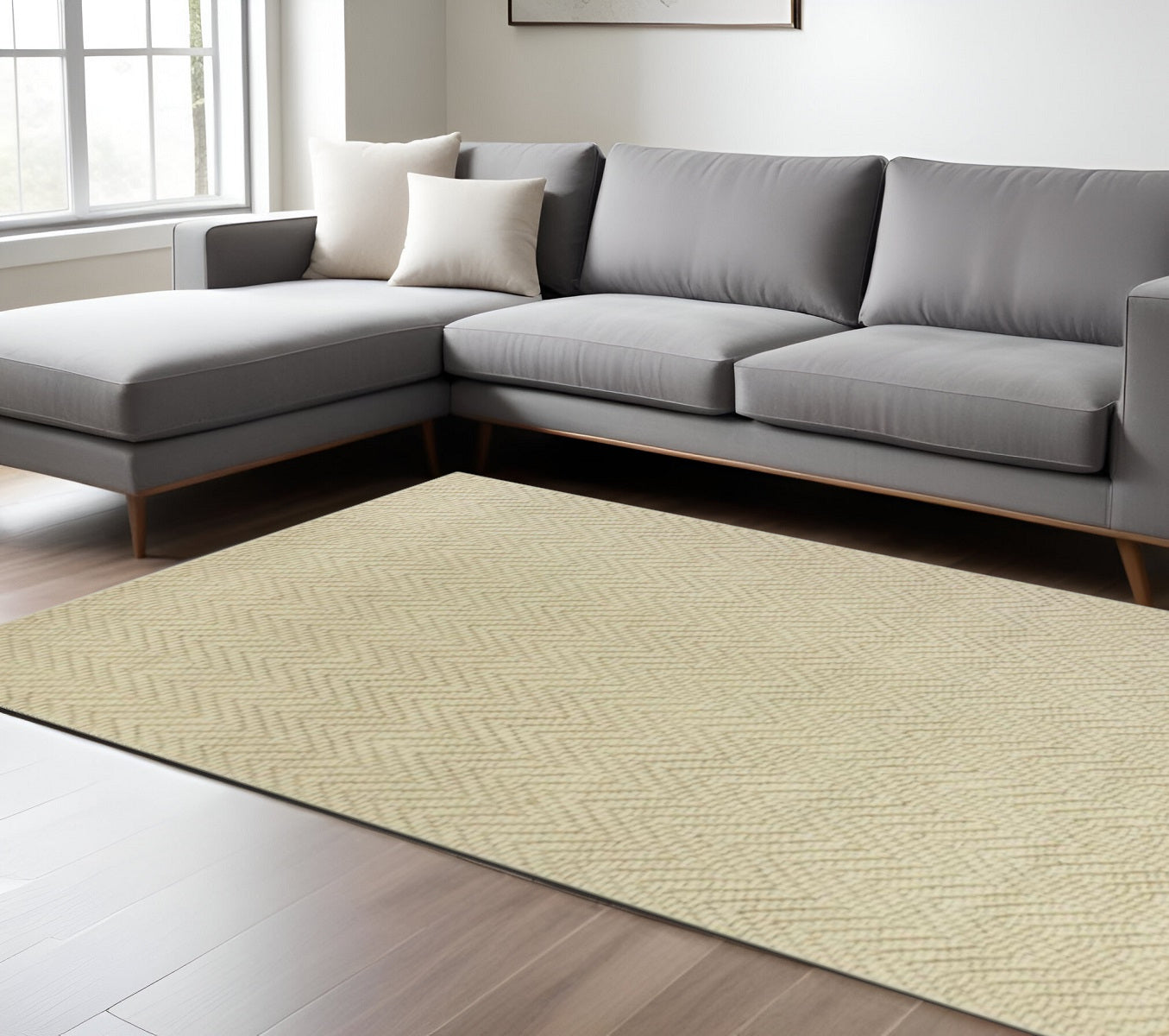 Gray sectional sofa with white cushions on a beige patterned rug in a living room.