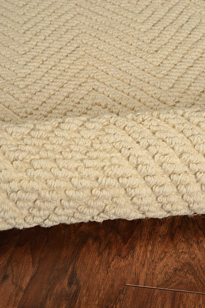 Close-up of a textured beige rug on a wooden floor