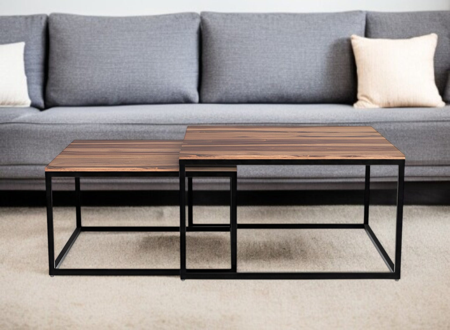 Two wooden coffee tables with metal frames in front of a gray sofa.