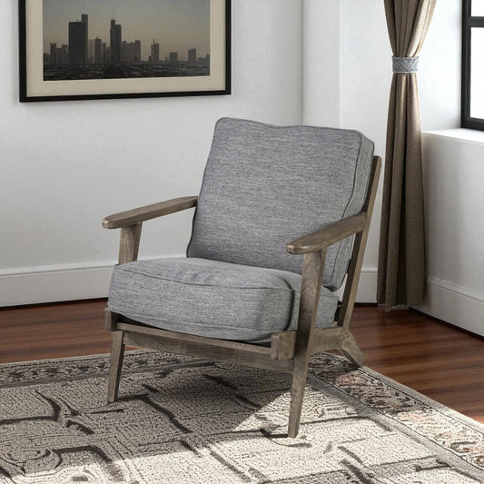 Gray armchair in a room with a cityscape painting and curtains.