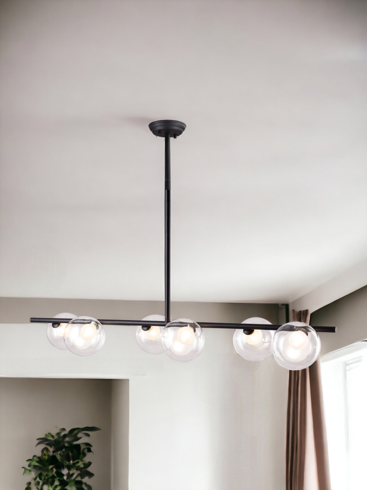 Modern ceiling light fixture with three glass bulbs in a minimalistic room.