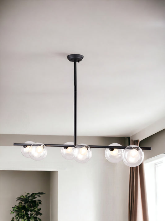 Modern ceiling light fixture with three glass bulbs in a minimalistic room.