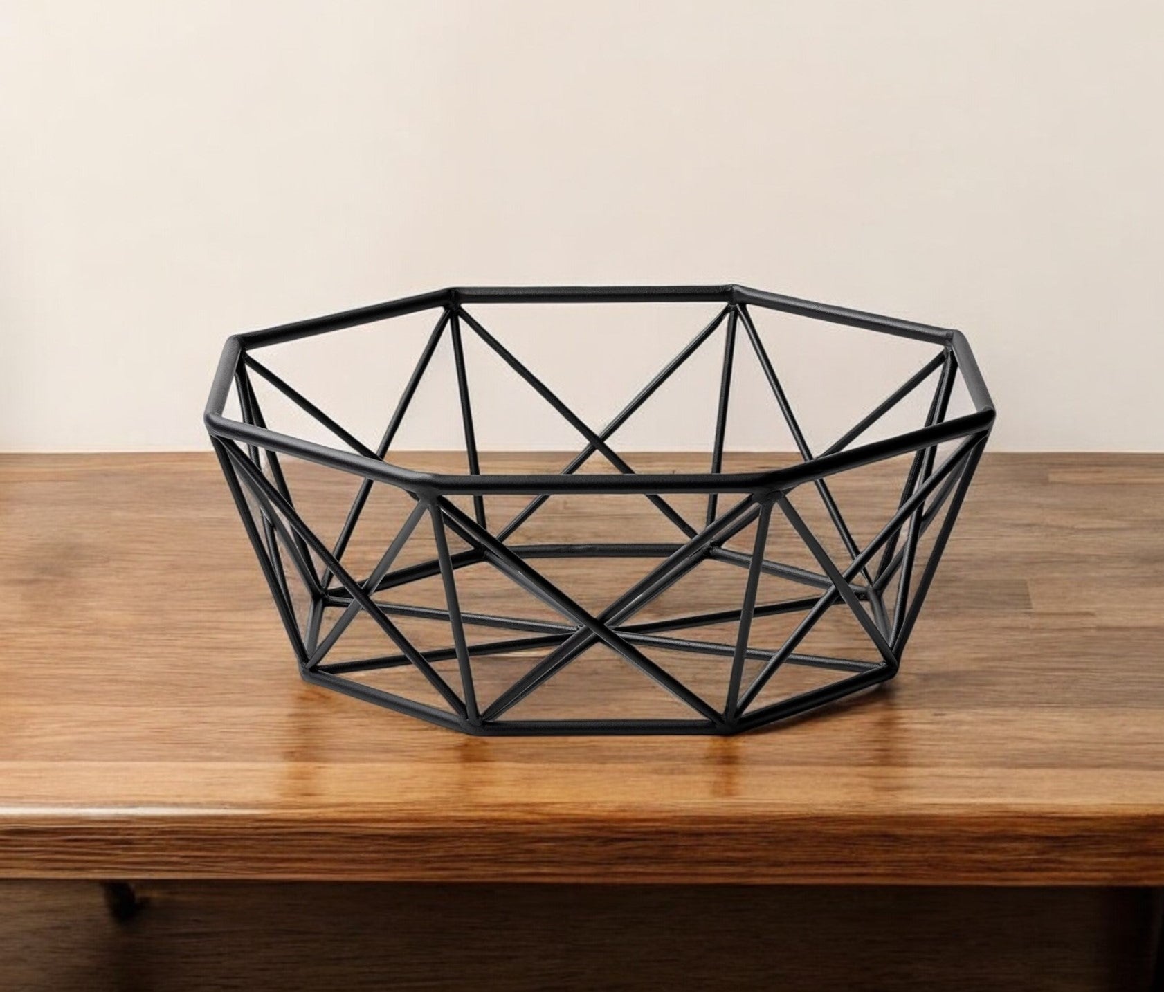 Geometric black metal bowl on a wooden surface with a plain background
