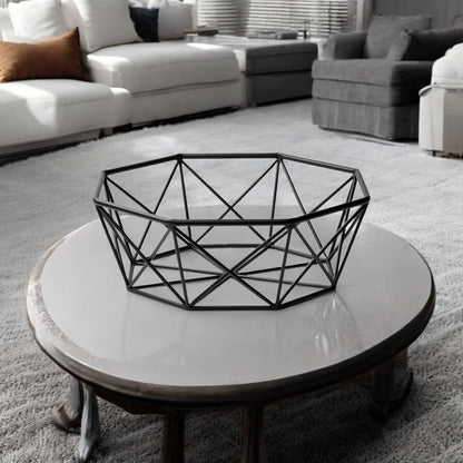 Geometric black wire basket on a round white coffee table in a living room setting.