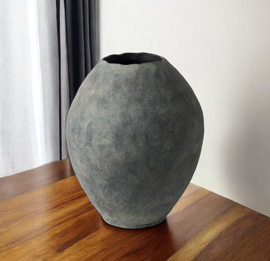 Textured gray vase on a wooden surface with a neutral background