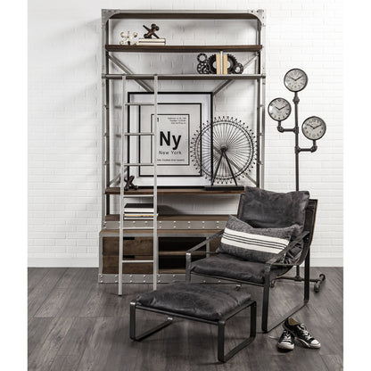 Modern interior with a dark gray armchair, ottoman, and decorative items on a white brick wall.
