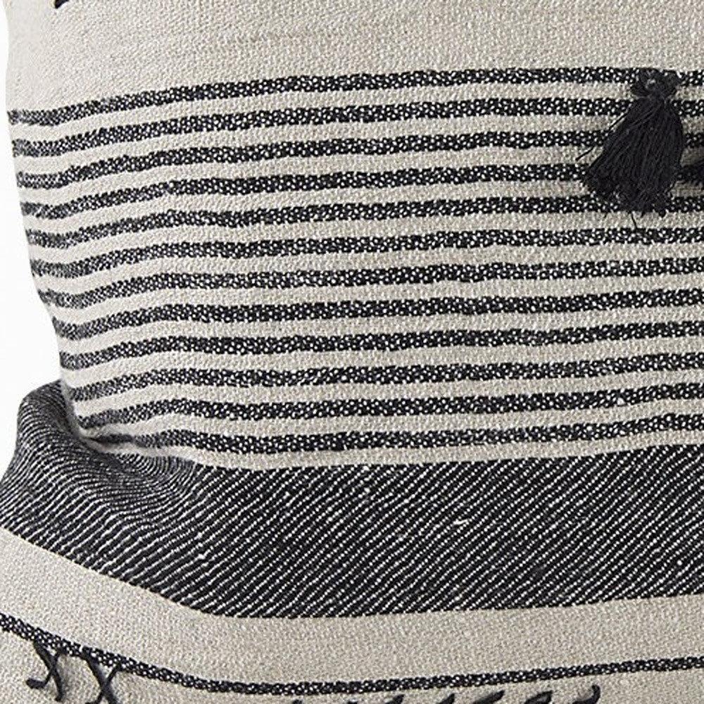 Close-up of a striped fabric with a tassel on a product, likely a bag or pouch.