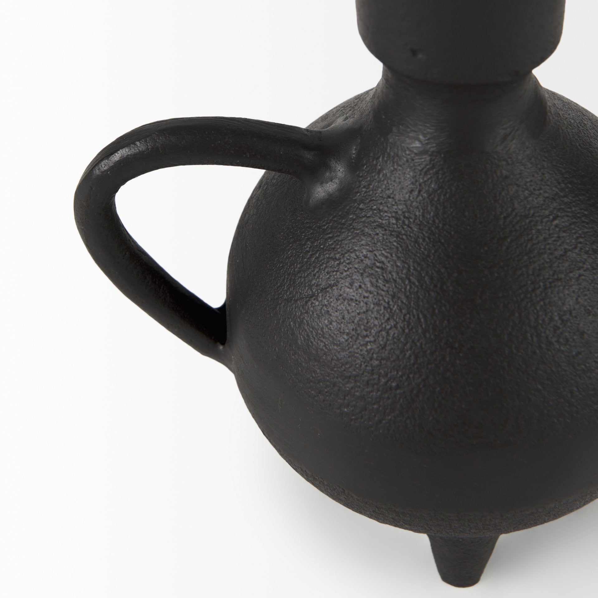 Black ceramic vase with a handle on a white background