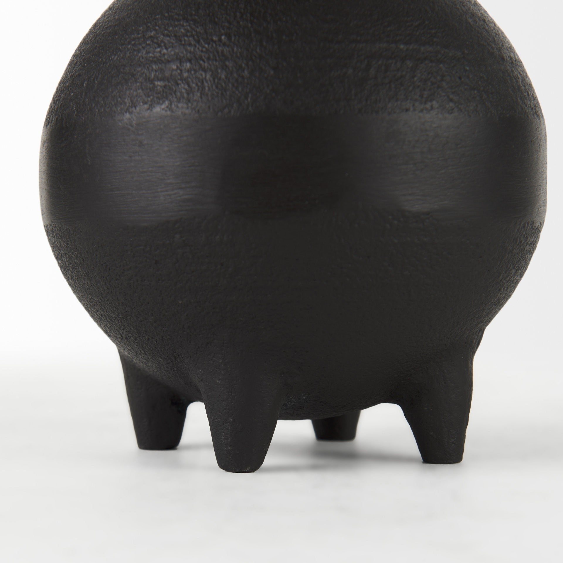 Black ceramic vase with a textured surface on a white background