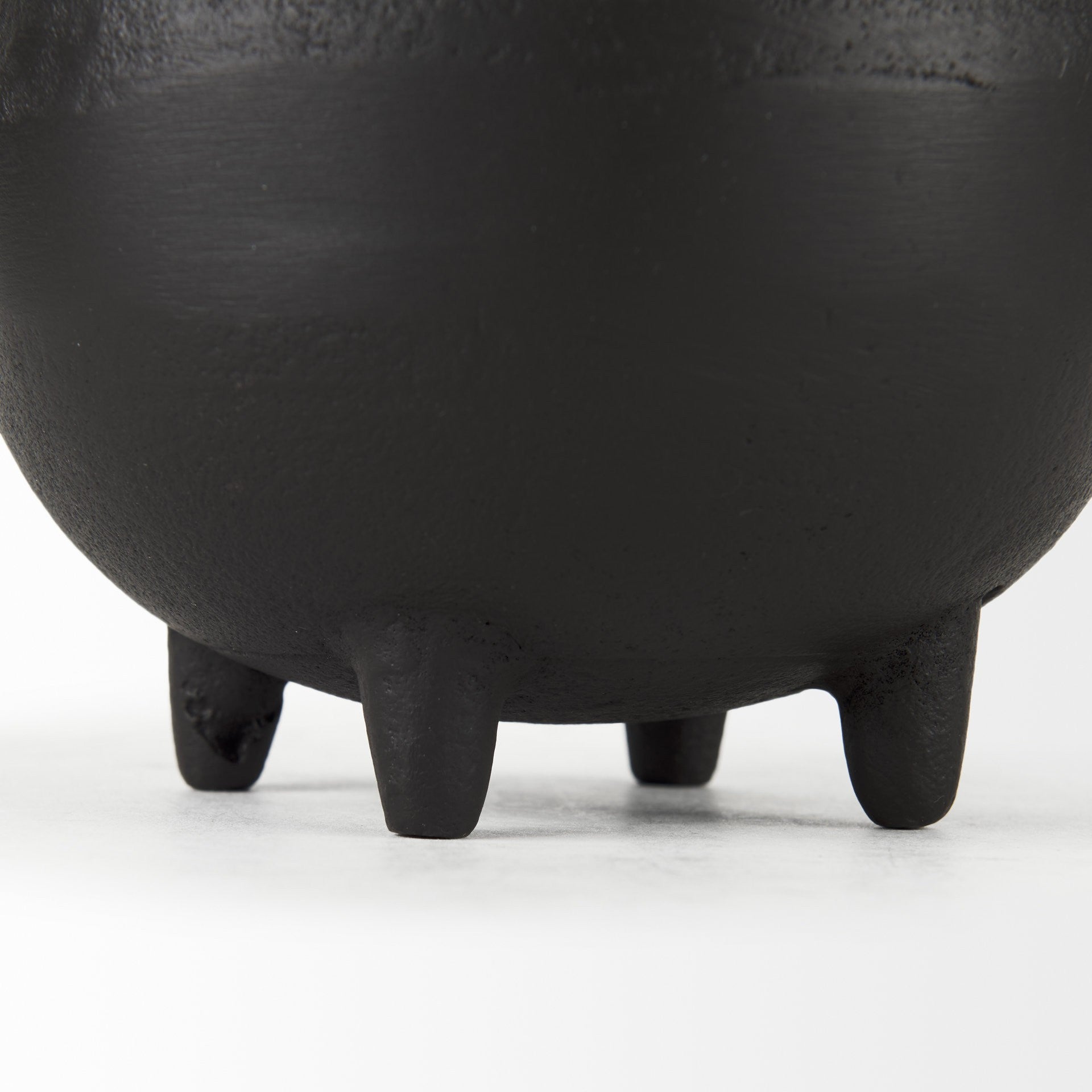 Close-up of a black ceramic pot with a white background