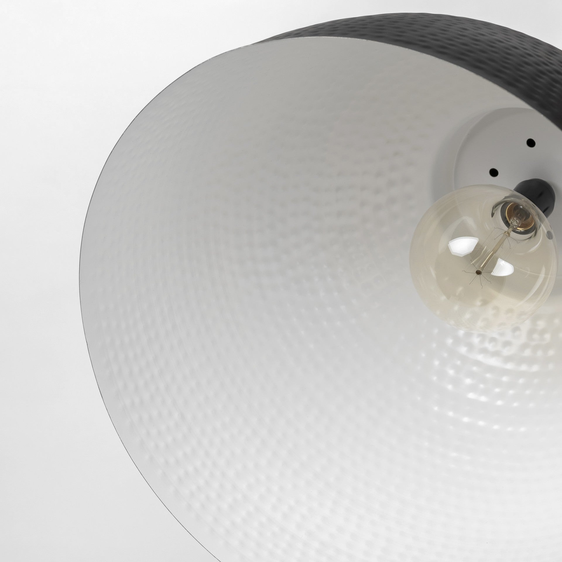 Close-up of a ceiling light fixture with a textured white shade and visible bulb.