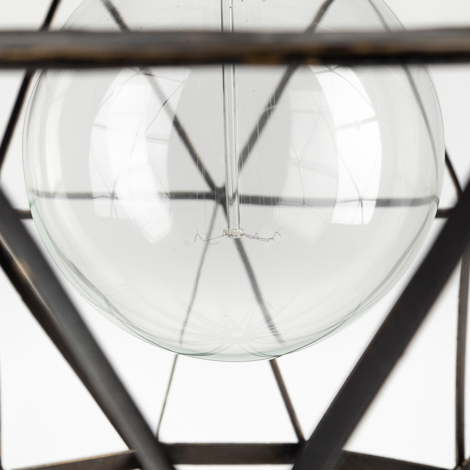 Close-up of a clear glass sphere with metal frame on a white background