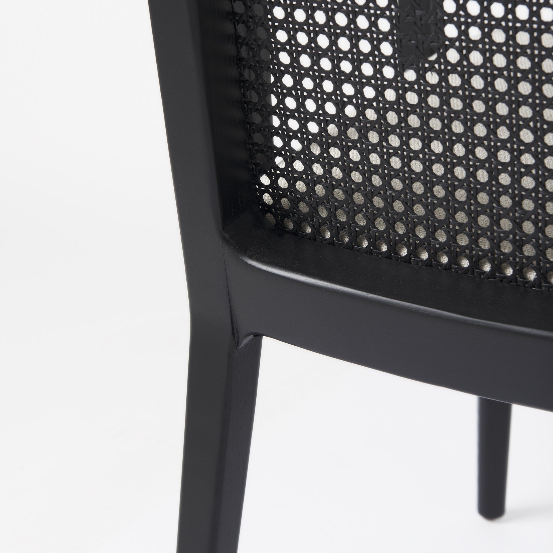 Close-up of a black chair with woven backrest on a white background
