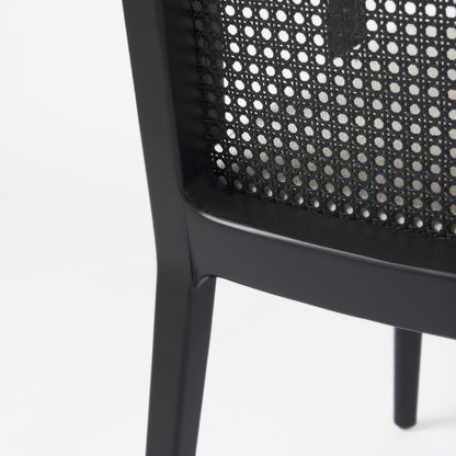 Close-up of a black chair with woven backrest on a white background